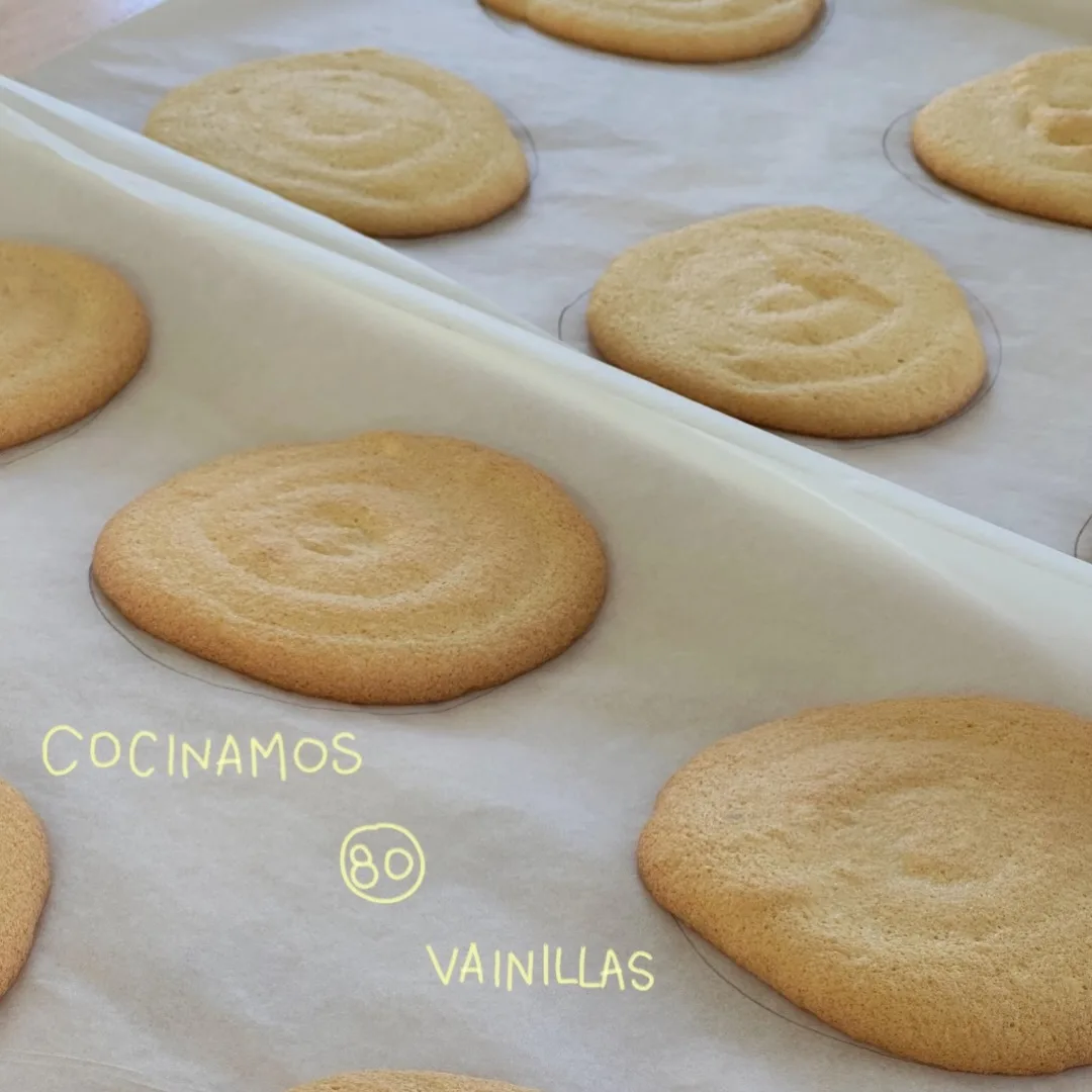 Bandeja de vainillas caseras recién horneadas, con «cocinamos 80 vainillas» escrito a mano encima